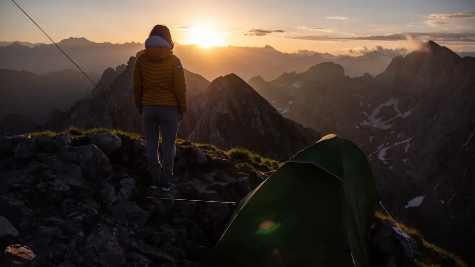Solo hiker standing on mountain summit breathing fresh air without digital devices