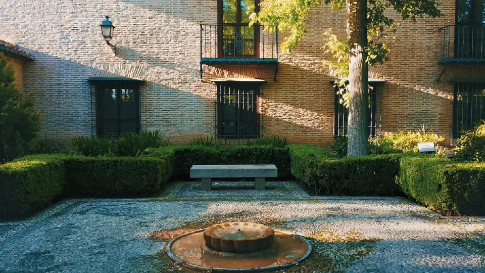 Peaceful scholar walking through serene courtyard garden in deep contemplation