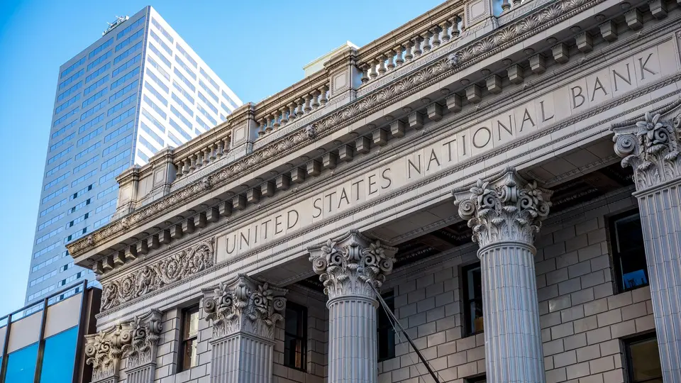 Towering neoclassical stone columns and bronze doors of national central bank building