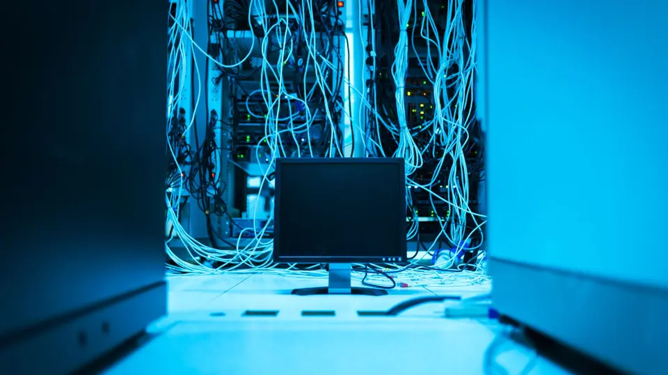 Underground server room with flickering red warning lights and severed cables