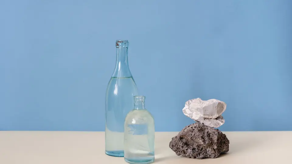Sleek health supplement bottles, smart ring, and glass of filtered water on marble counter